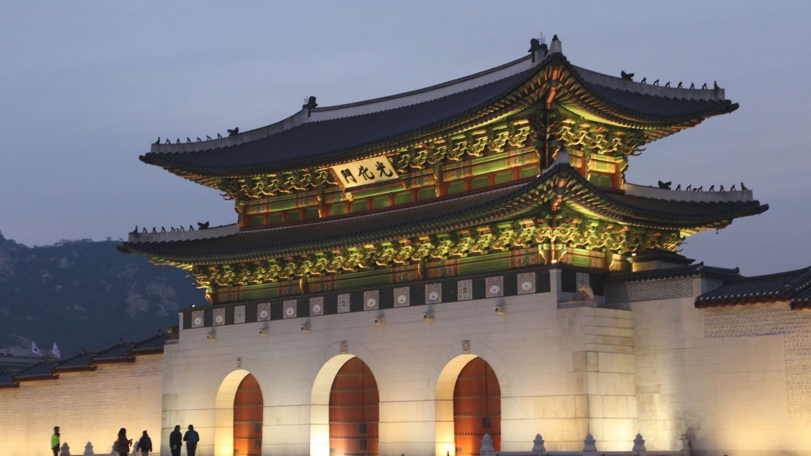 Portão Gwanghwamun iluminado ao anoitecer, em Seul